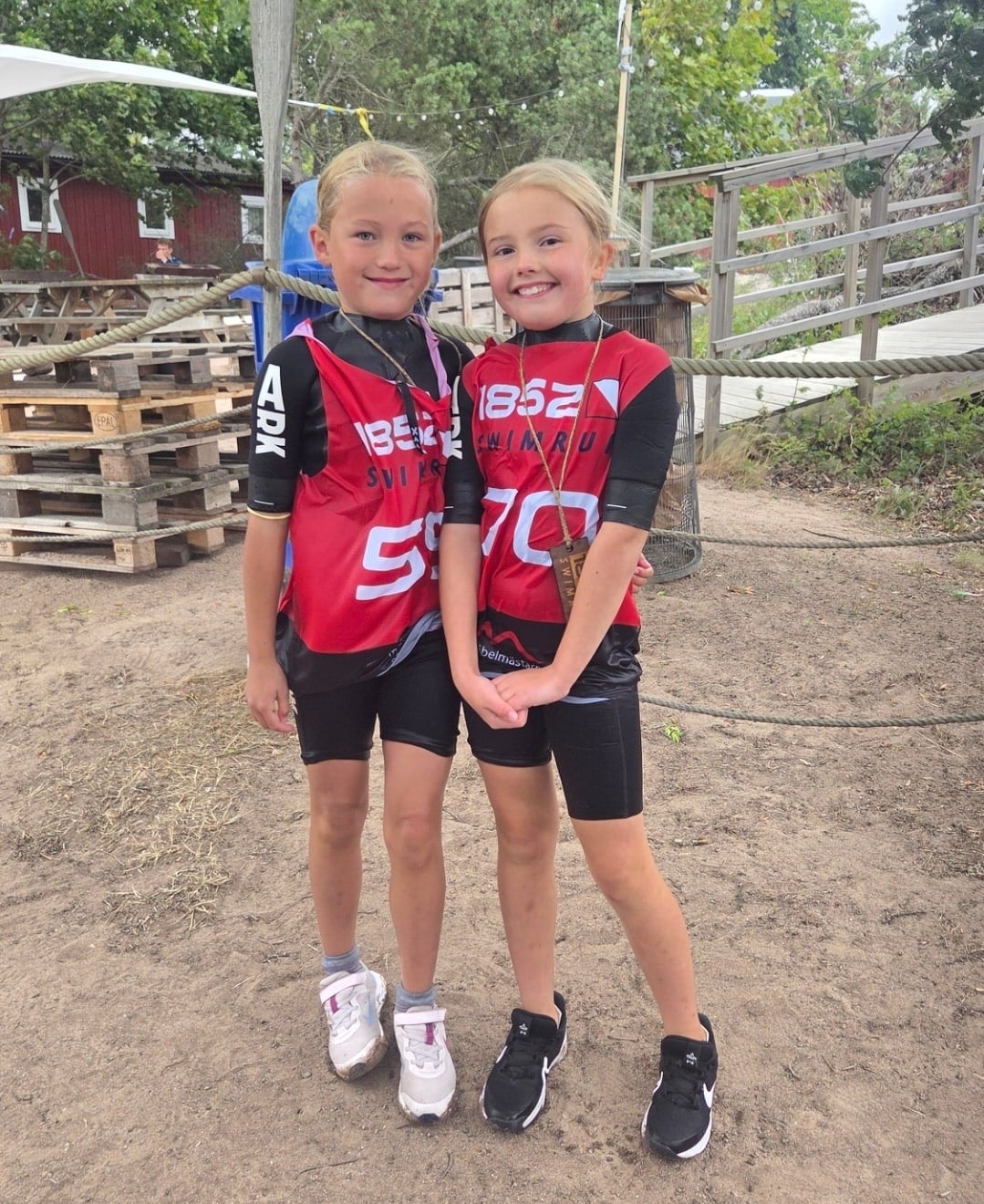 Två deltagare i 1852-västar står tillsammans med sina träpriser efter loppet